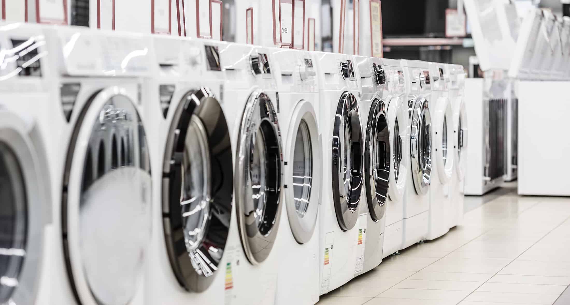 A row of washing machines in a store.